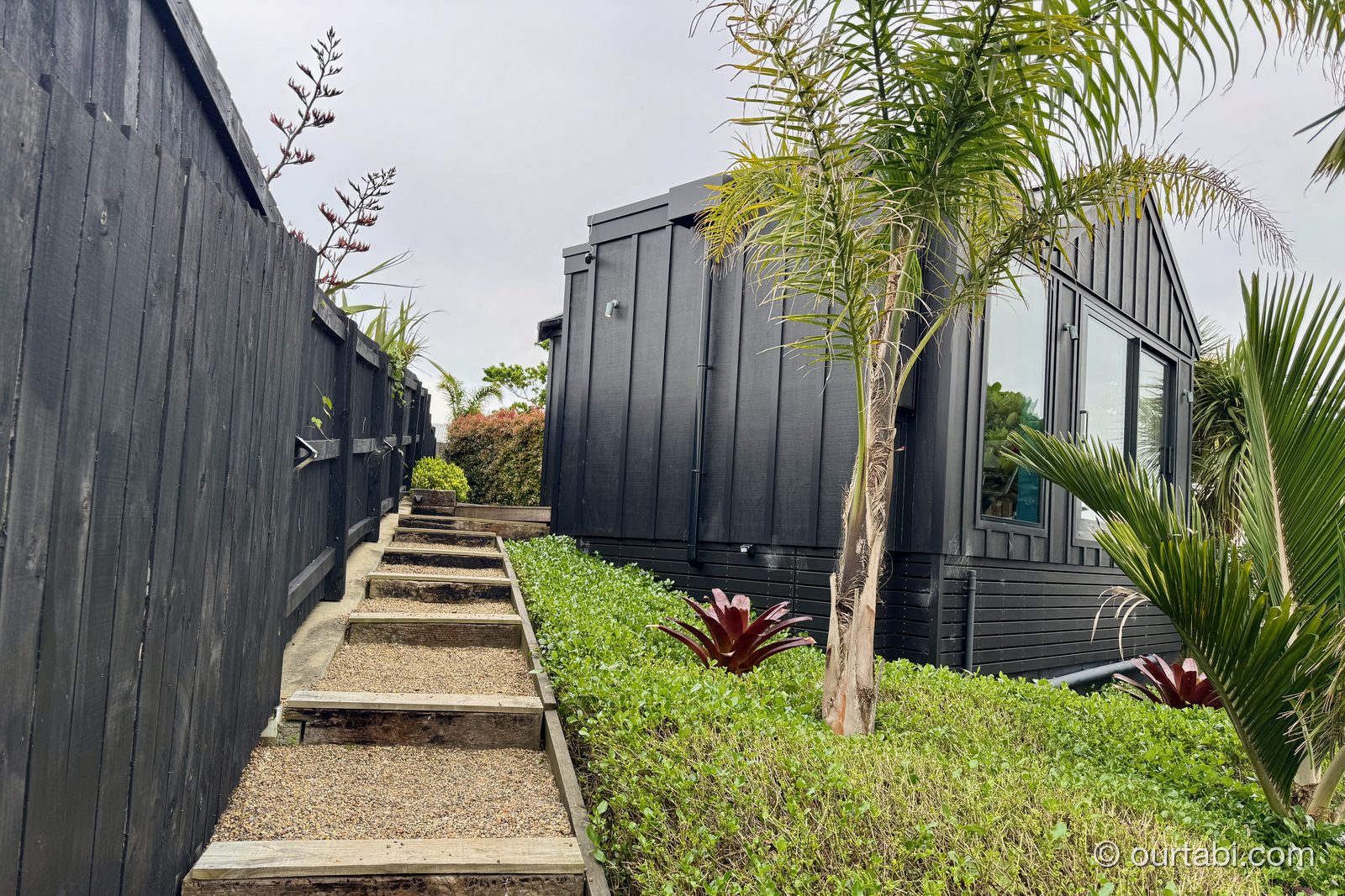 Whare Itiの建物脇の通路とヤシの木