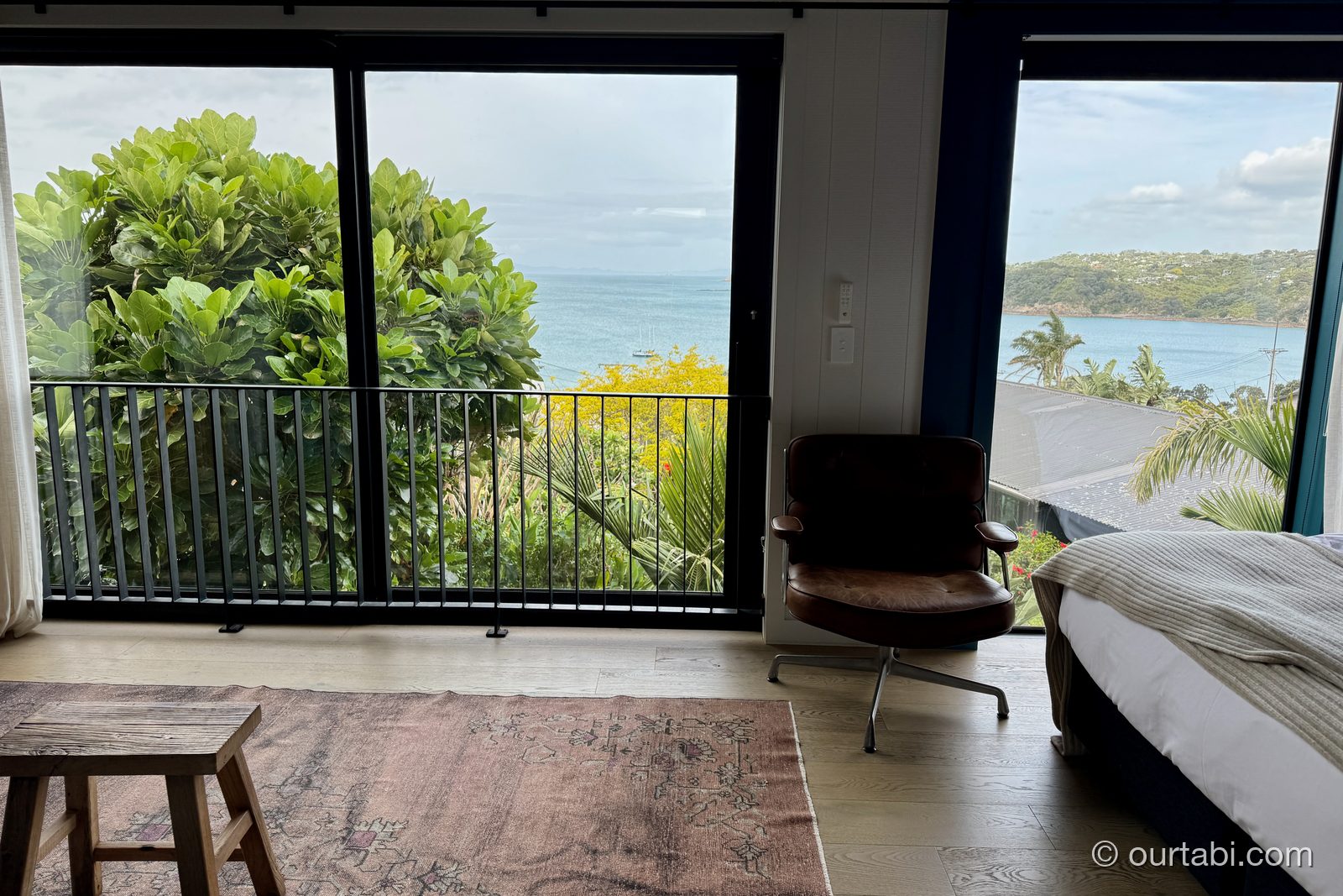 Whare Itiの室内からバルコニーと海を見た様子