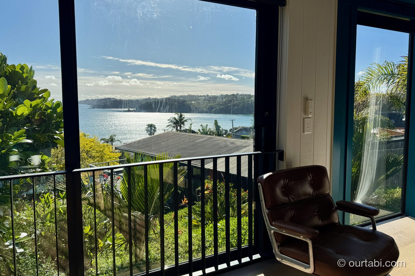 Whare Itiのバルコニーの椅子と湾の景色