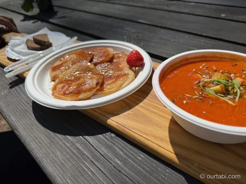 木のテーブルに置かれたトマトスープとパンケーキ