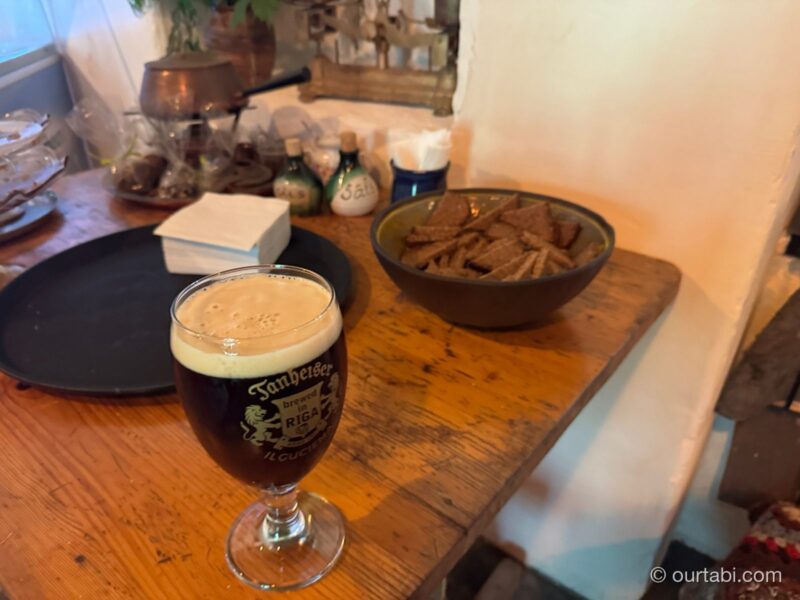 黒ビールのグラスと、器に入った黒パンのスナック