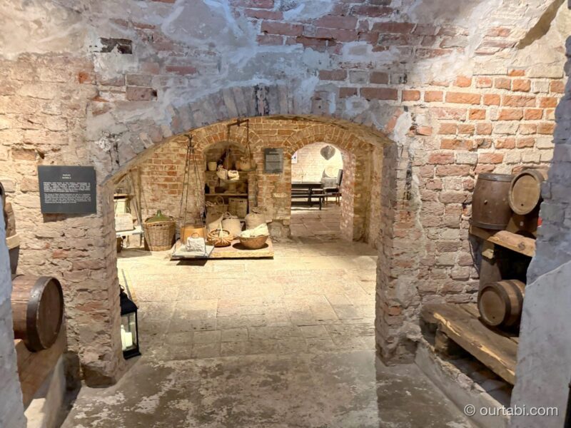 地下の古いレンガの壁と、アーチの奥の展示