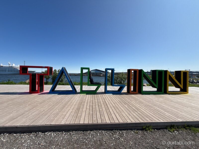港沿いに並ぶカラフルなTALLINNの文字のモニュメントと青空