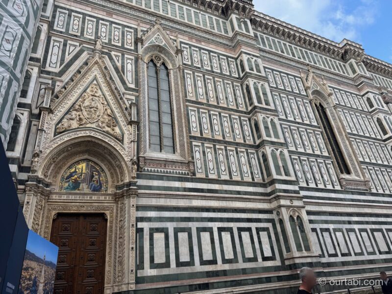 モザイクの半円のある、ポルタ・デッラ・マンドルラの木の扉