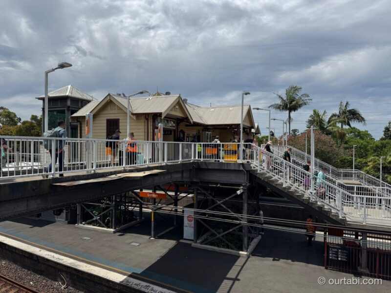 Gordon駅の跨線橋と駅舎、階段を上がる人たち